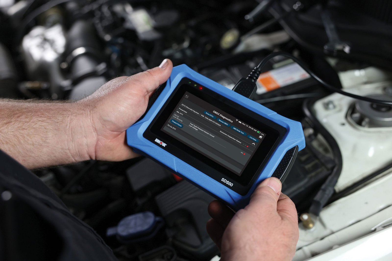 Mechanic using a diagnostic scan tool on a vehicle's check engine light